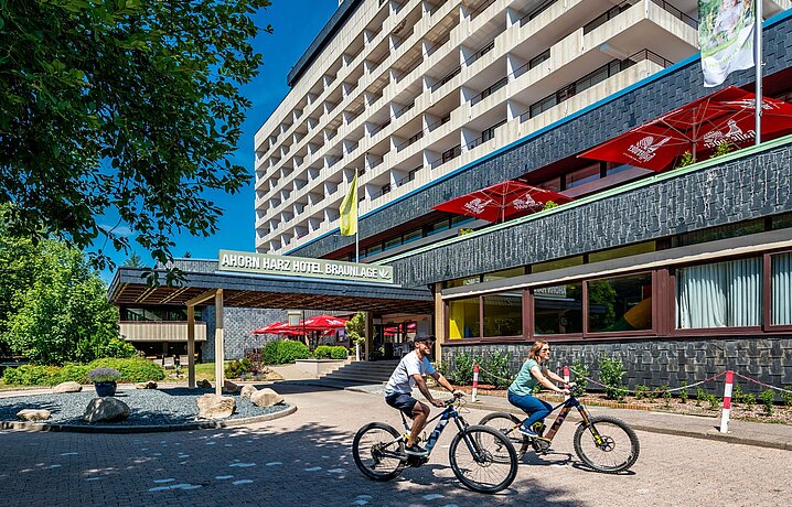 AHORN Harz Hotel Braunlage Aussenansicht im Sommer mit Radfahrern